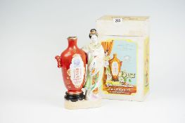 An early 20th Century Chinese liqueur flask vase with standing Oriental lady alongside, on an oval