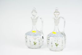 A pair of late Victorian glass decanters with painted floral decoration and bell knops.