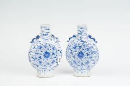 A pair of late 18th Century blue and white narrow necked Oriental flask vases each with twin