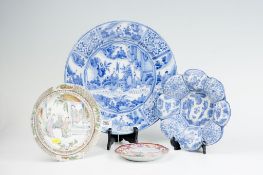 A large 19th Century Delft style blue and white platter; a circular petal shaped dish with figure