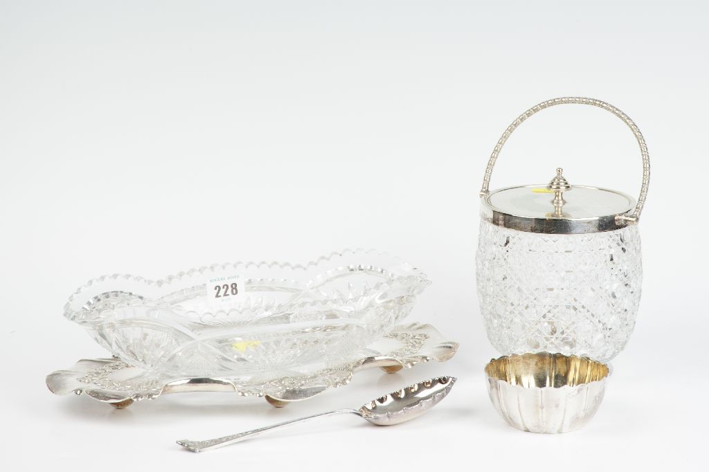 A heavy cut glass fruit serving dish on a shaped and decorated electroplated stand with serving