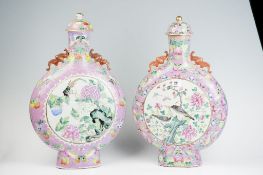 A pair of 18th Century famille rose Chinese moon flask vases, the narrow necks having domed covers