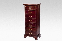 A reproduction narrow hardwood seven drawer chest with brass drop handles, 20 ins (51 cms) wide.