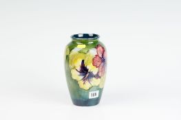 A green ground Moorcroft `Hibiscus` vase with Queen Mary label to the base, 8.25 ins (21 cms) high.
