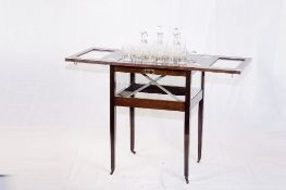 A polished cantilever drinks cabinet, the twin top doors having bevelled glass panels and the `