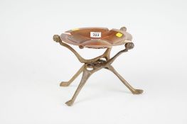 A heavy circular Rhodesian copper cigar or cigarette dish on a folding carved wood native stand,