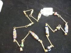 A yellow metal link necklace with mosaic tablets.