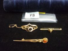 A nine carat gold pin brooch, a believed nine carat gold Celtic type pin with amber stone and a