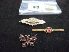Three gold and yellow metal brooches - one a butterfly brooch with garnets, and two bar brooches;