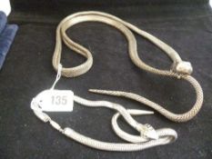 Two white metal decorative serpent belts.
