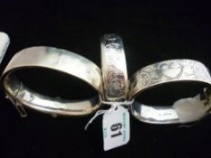 Two silver half bright cut hollow bangles and another, believed silver but unmarked (impact damage