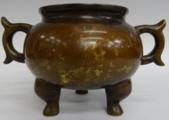 A twin handled three-footed globular shaped Chinese bronze censer, 6 ins (15 cms diameter at top,