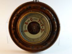 A circular Edwardian mahogany framed aneroid wall barometer, 11 ins (28 cms) diameter