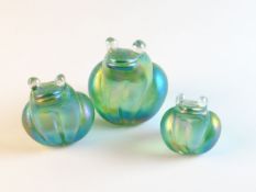 A graduated set of three green lustrous crouching frogs by J Ditchfield
