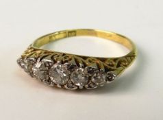 AN EDWARDIAN DIAMOND DRESS RING; With five graduated diamonds in tension settings interspersed