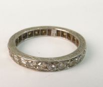 A DIAMOND ETERNITY RING; Modern brilliant cut diamonds to white metal mount with engraved decoration