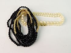 A GROUP OF NECKLACES; Two onyx and yellow metal bead necklaces and the other a string of cultured