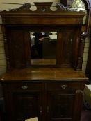 An Edwardian mahogany sideboard with mirrored and shelved back, two short drawers over two