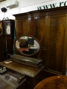 An early 20th Century three piece mahogany bedroom suite of double wardrobe, dressing table and