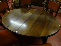 An early 20th Century oval mahogany expanding dining table with four splayed legs