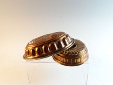 Two Victorian copper jelly moulds, one of oval form with coffee related decoration to top; the other