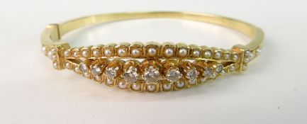 A GOLD, DIAMOND AND SEED PEARL BANGLE; Victorian style with nine graduated modern brilliant cut