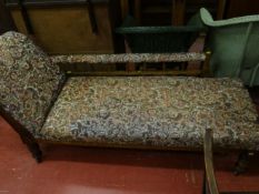 An Edwardian chaise longue with railed and fabric armrest in floral tapestry upholstery