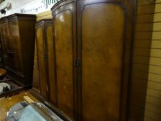 A pair of circa 1950s two door wardrobes, one of larger proportions and both with burr walnut