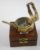 A contemporary brass ships compass with enclosed lid revealing mirror in wooden box
