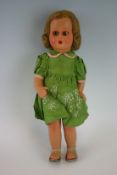 An early to mid 20th Century doll, possibly European, ceramic head and body with opening eyes and