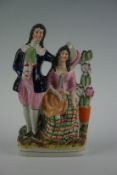 A 19th Century Staffordshire model of a courting couple in Highland dress, 10.75 ins (27.5 cm) high