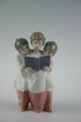 A Lladro figurine of group of three choir boys singing, 7.5 ins (19 cms)