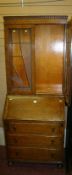 A polished small bookcase bureau in the Art Deco style, the top having twin glazed doors with leaded
