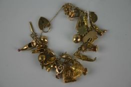 1960`s gold (9ct) charm bracelet with twenty one gold (9ct and 18ct) charms on fancy link chain with