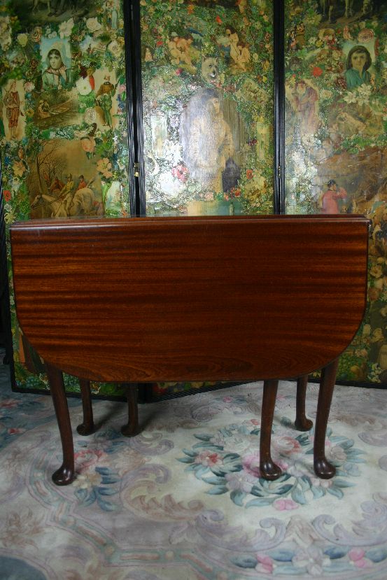 An early 20th Century mahogany dropleaf tea table with cabriole supports and bun feet