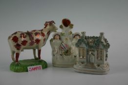 Seven items of 19th Century Staffordshire pottery including a lustre cow creamer; peasant group