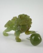 An Oriental jade figure of a Dog of Foe with foot on ball and roaring mouth, 5.25 ins long
