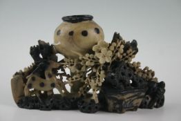 A soapstone spill with wildlife decoration and of black and taupe colouring, 6.5 ins high, 10.5