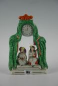 A 19th Century Staffordshire model of a pair of minstrels on stage beneath curtain and clock