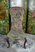 A Victorian mahogany spoonback chair with cabriole supports and floral tapestry seat and back