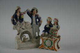 A 19th Century Staffordshire peasant couple with swan; and a Staffordshire peasant clock group