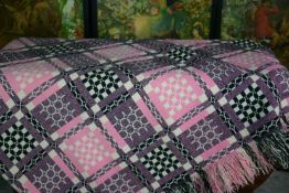 An early to mid 20th Century pink and black fringed Welsh quilt