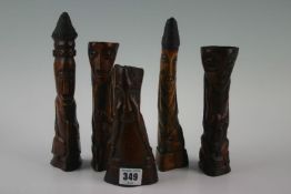 Five African stained bone figures in the form of miniature totem poles, various measurements