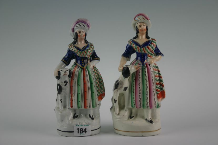 A pair of Staffordshire `Scottish Highlander` ladies with dogs