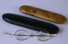 A pair of late nineteenth century yellow metal spectacles with thick bevelled oval eye glasses in