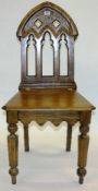 Victorian oak hall chair with Gothic arched back, turned octagonal front legs and waved apron.