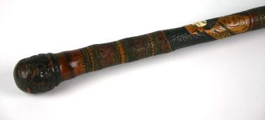 An early twentieth century dyed and carved bamboo walking stick with inset ivory faces to figures