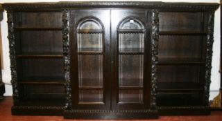 A late 19th/early 20th Century ornately carved breakfront sideboard with two central glass