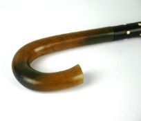 An early twentieth century mahogany, ivory and horn walking cane with tapered cylindrical stick
