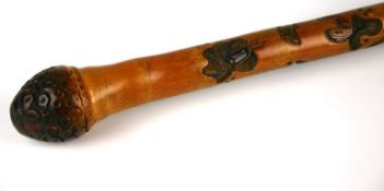 An early twentieth century Japanese bamboo carved walking stick with a carved series of snakes